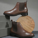 Black leather Classic Chelsea boot with elastic side panels, pull-tab at the heel, rounded toe, and a small metallic brand logo near the ankle.