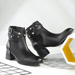 Women Black studded leather ankle boots with studded straps and a buckle design.