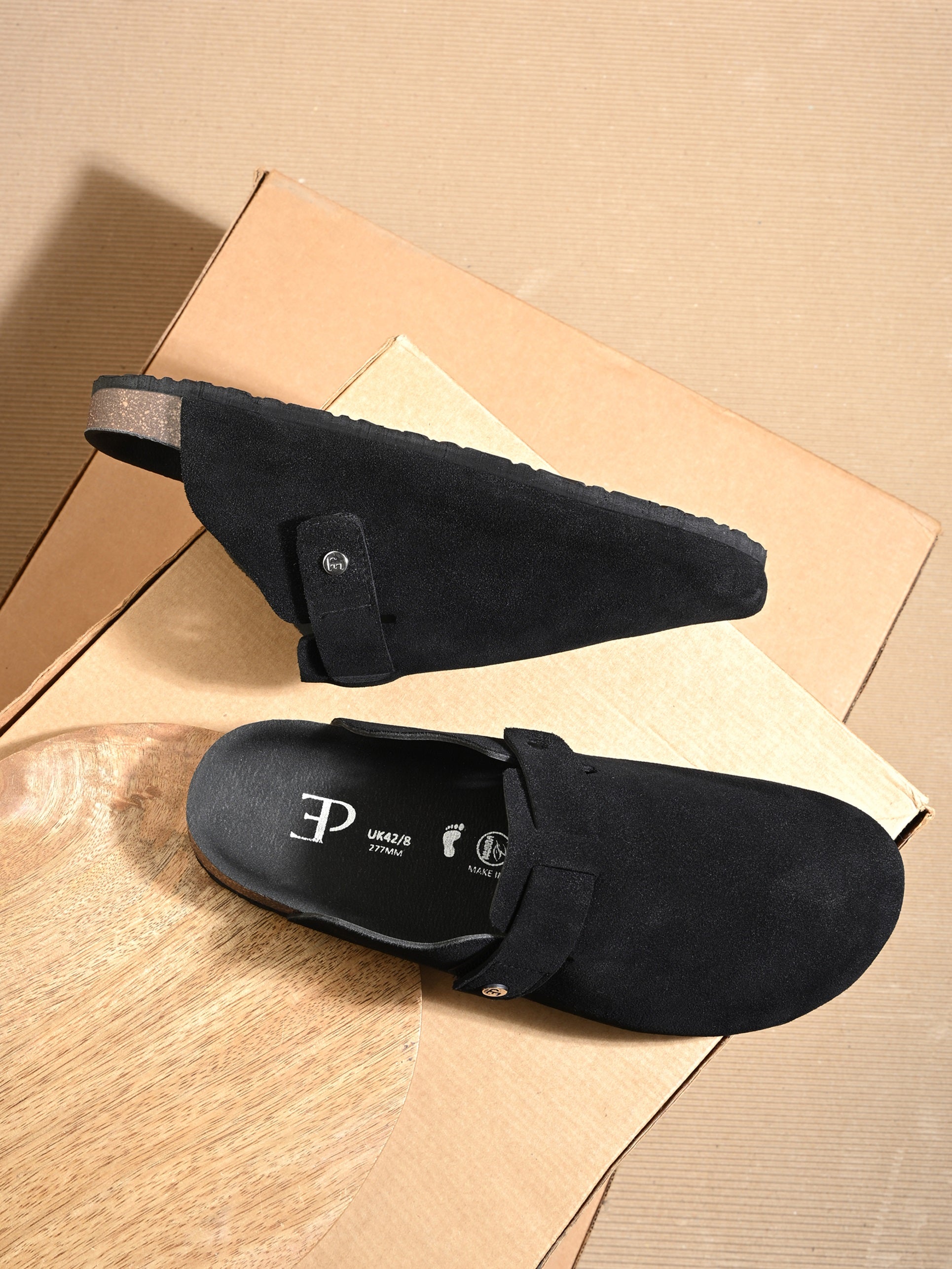 Black suede slip-on clog with a black rubber sole, adjustable strap, and Boston Soft Footbed for enhanced comfort and support.