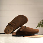 Brown suede slip-on clog with a black rubber sole and adjustable strap.