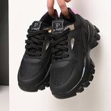 A pair of black El Paso lace-up women's sneakers with chunky soles, mesh detailing, and subtle pink and white accents.