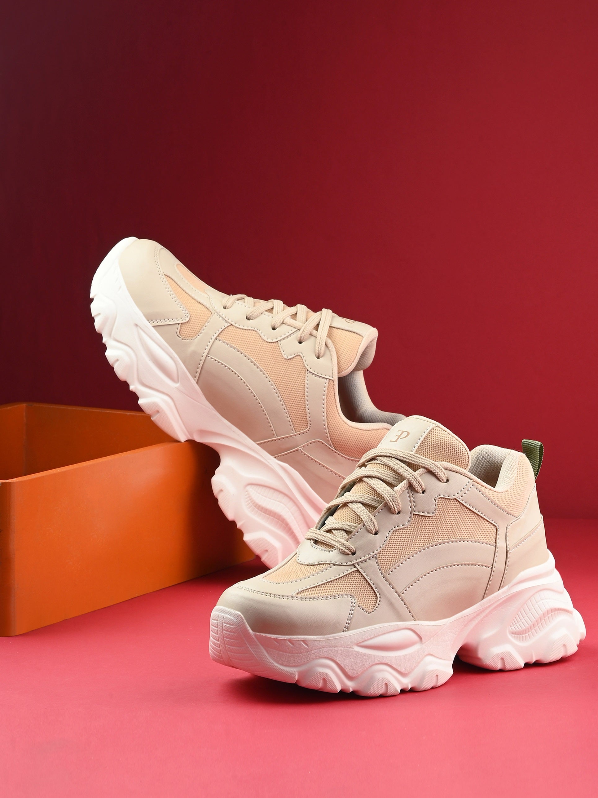 Beige chunky sneakers with a textured sole and mesh accents.