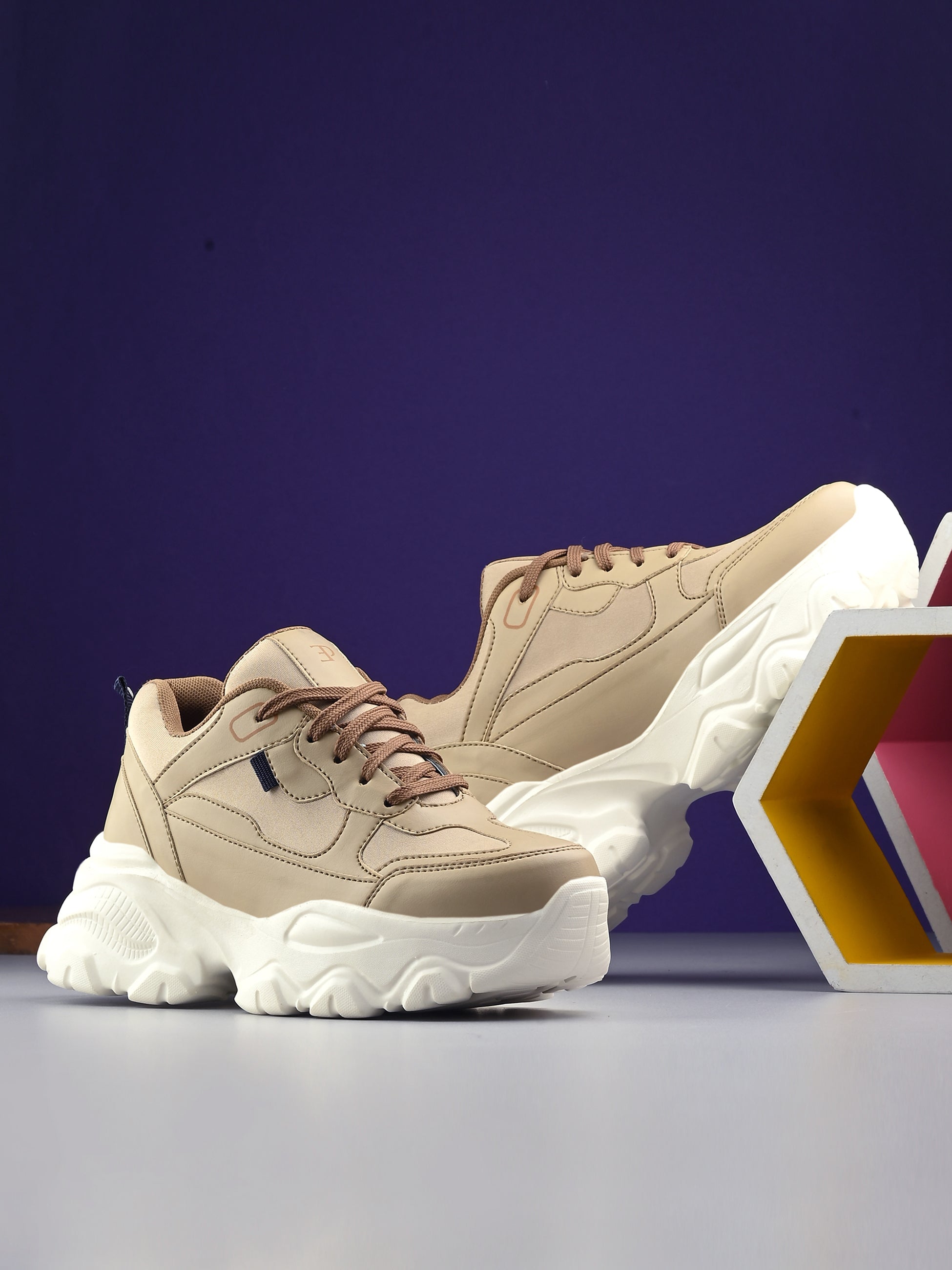 Beige chunky sneaker with a textured white sole, brown laces, and modern detailing, designed for casual and stylish wear.