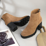 Glossy camel patent leather zip-closure ankle boot with a chunky block heel, lug sole, and a gold logo detail near the collar.