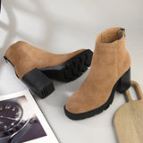 Glossy camel patent leather zip-closure ankle boot with a chunky block heel, lug sole, and a gold logo detail near the collar.