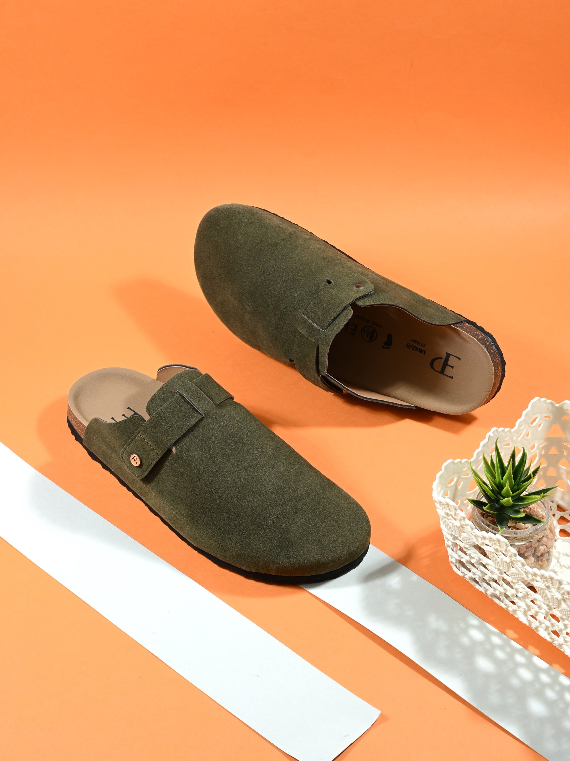 Olive suede slip-on clog with a black rubber sole and adjustable strap.