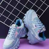 A pair of blue El Paso lace-up women's sneakers with chunky soles, mesh detailing, and subtle pink and white accents.