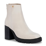 Glossy beige patent leather ankle boot with a chunky block heel, lug sole, and a gold logo detail near the collar.