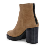 Glossy camel patent leather ankle boot with a chunky block heel, lug sole, and a gold logo detail near the collar.