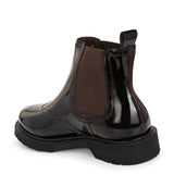 A glossy Wine Chelsea boot with brogue detailing, elastic side panels, and a durable black sole, featuring a gold accent logo.