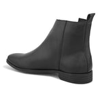 A sleek black leather Chelsea boot with a side zipper, pull-tab at the back, and a low block heel.