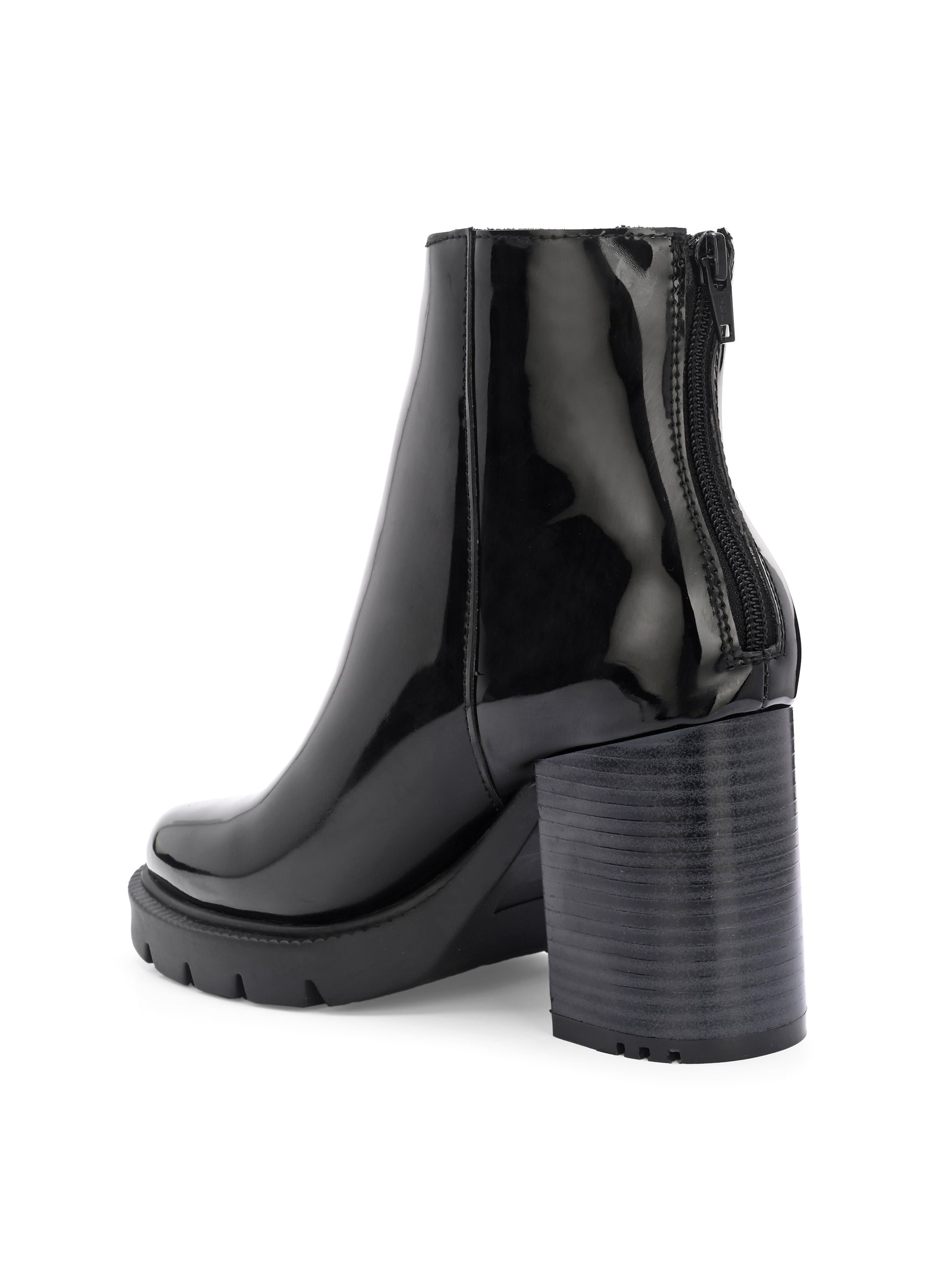Glossy black patent leather ankle boot with a chunky block heel, lug sole, and a gold logo detail near the collar.