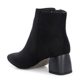 Suede ankle boot with pointed toe, chunky block heel, side zipper, and gold logo detail near the top.