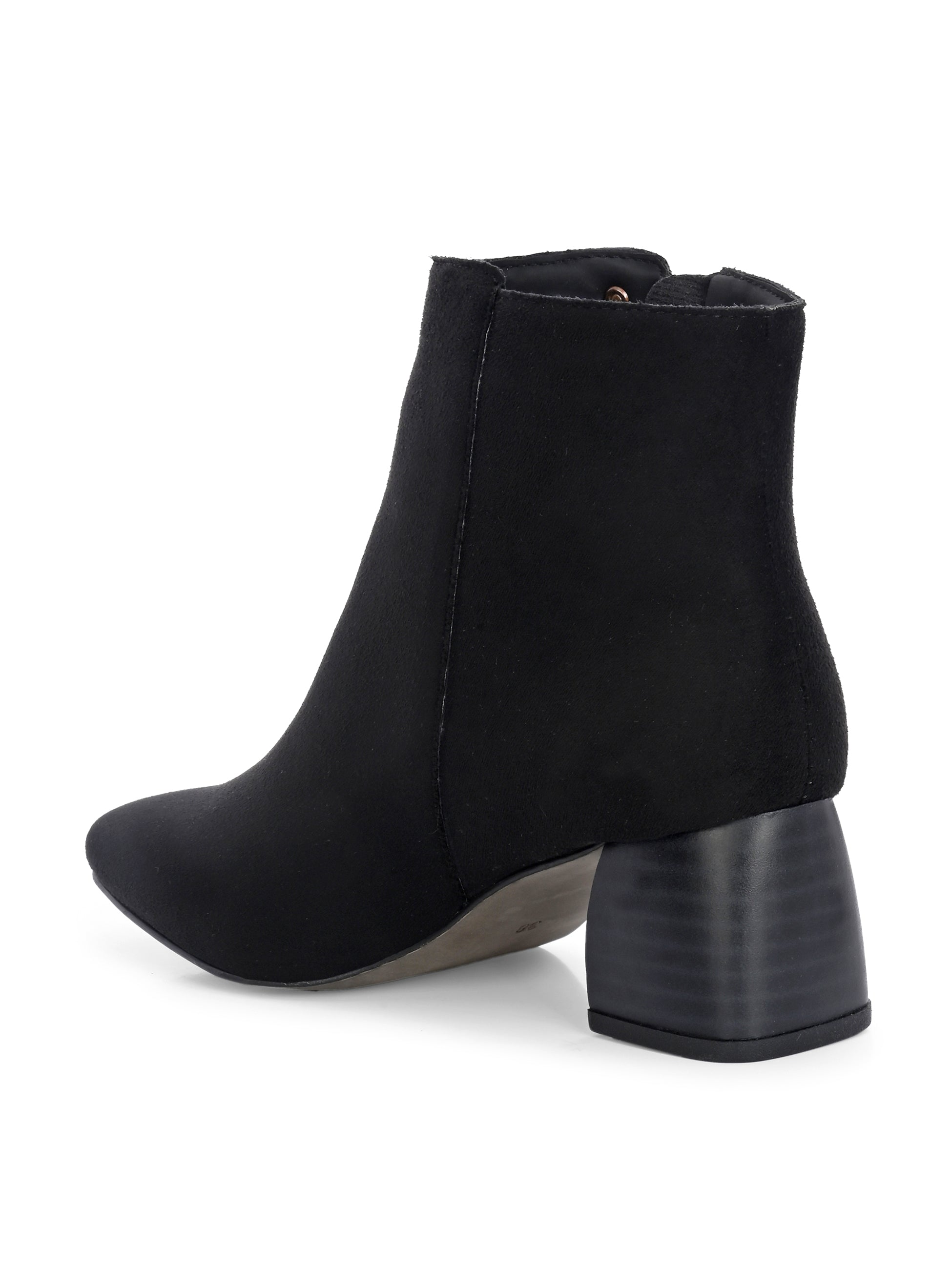Suede ankle boot with pointed toe, chunky block heel, side zipper, and gold logo detail near the top.