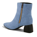 Light blue suede ankle boots with a sleek design and block heel.