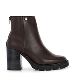 Glossy brown patent leather ankle boot with a chunky block heel, lug sole, and a gold logo detail near the collar.