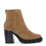 Glossy black patent leather ankle boot with a chunky block heel, lug sole, and a gold logo detail near the collar.