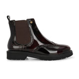 A glossy Wine Chelsea boot with brogue detailing, elastic side panels, and a durable black sole, featuring a gold accent logo.
