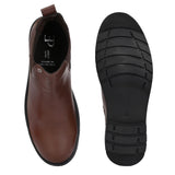 Brown Chelsea boots with elastic side panels, a pull-tab at the heel, rounded toe, and a small metallic brand logo near the ankle.