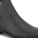 A sleek black leather Chelsea boot with a side zipper, pull-tab at the back, and a low block heel.