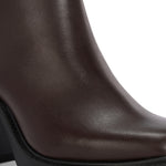 Glossy brown patent leather ankle boot with a chunky block heel, lug sole, and a gold logo detail near the collar.