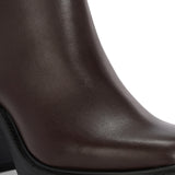 Glossy brown patent leather ankle boot with a chunky block heel, lug sole, and a gold logo detail near the collar.