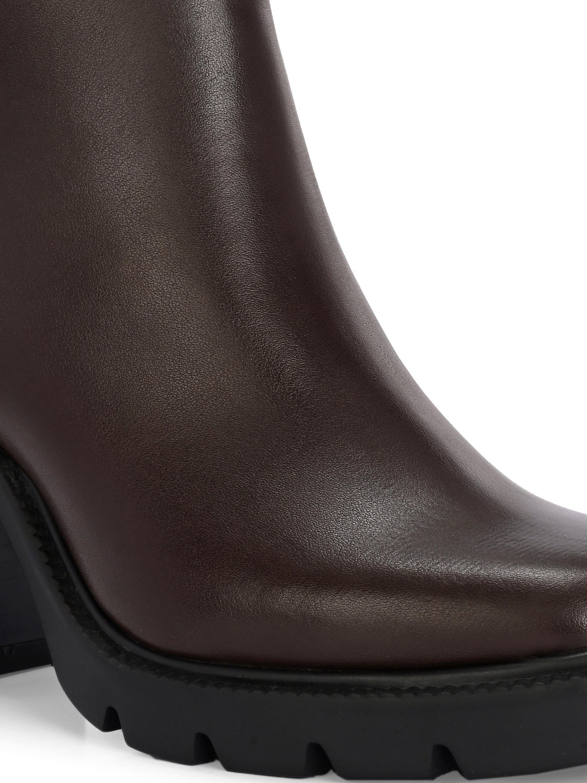 Glossy brown patent leather ankle boot with a chunky block heel, lug sole, and a gold logo detail near the collar.