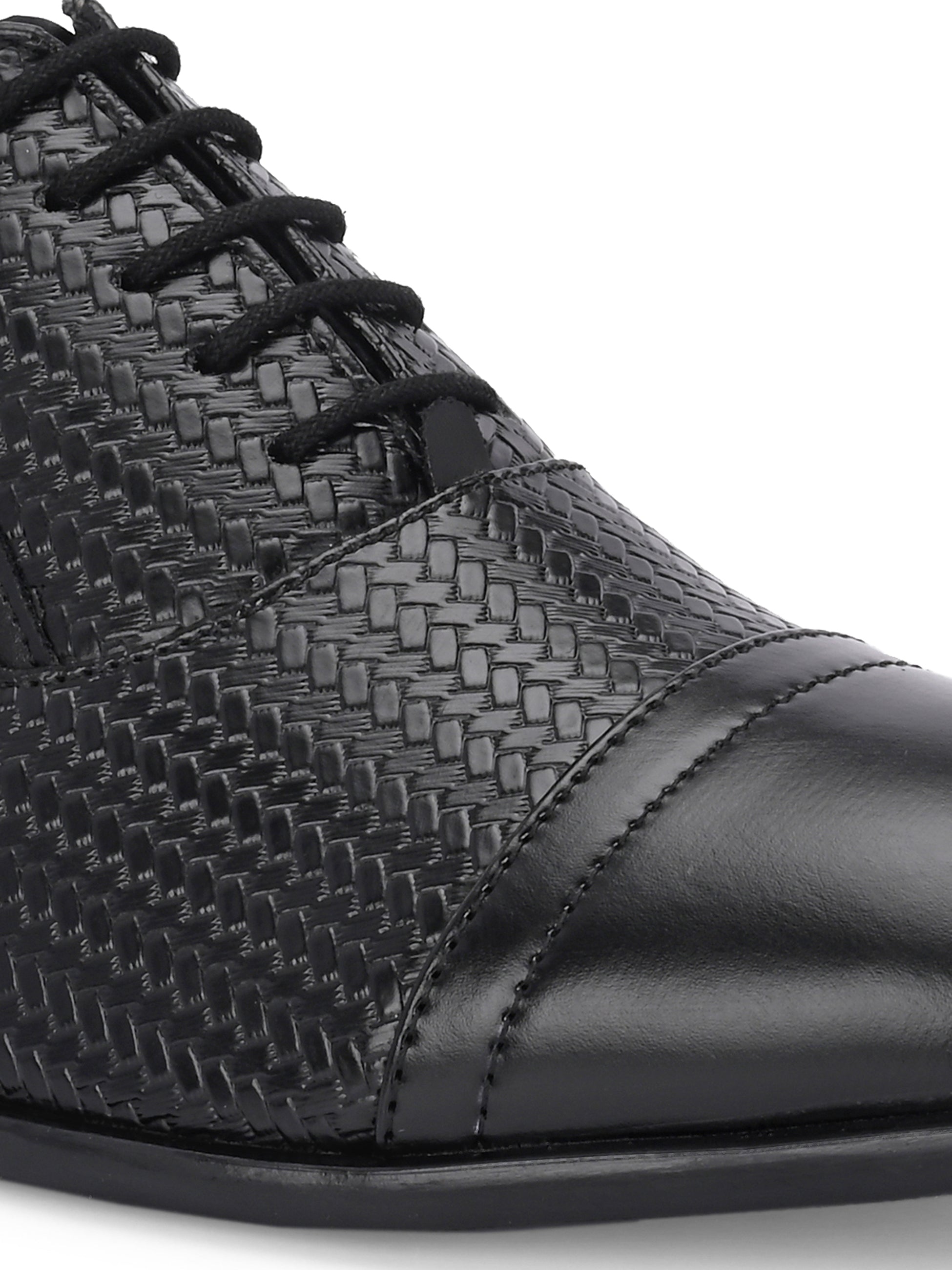 A black formal shoe with a textured pattern, lace-up design, and smooth toe cap.
