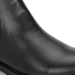 Classic Chelsea boots with elastic side panels, a pull-tab at the heel, rounded toe, and a small metallic brand logo near the ankle.
