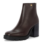 Glossy brown patent leather ankle boot with a chunky block heel, lug sole, and a gold logo detail near the collar.