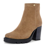 Glossy black patent leather ankle boot with a chunky block heel, lug sole, and a gold logo detail near the collar.