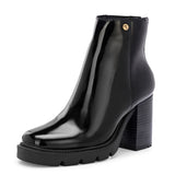 Glossy black patent leather ankle boot with a chunky block heel, lug sole, and a gold logo detail near the collar.