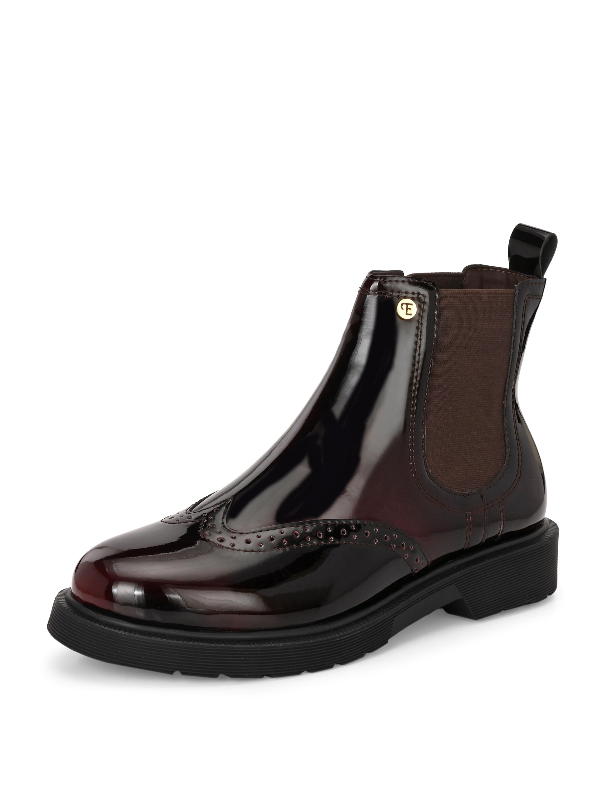A glossy Wine Chelsea boot with brogue detailing, elastic side panels, and a durable black sole, featuring a gold accent logo.