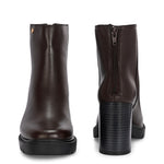 Glossy brown patent leather ankle boot with a chunky block heel, lug sole, and a gold logo detail near the collar.