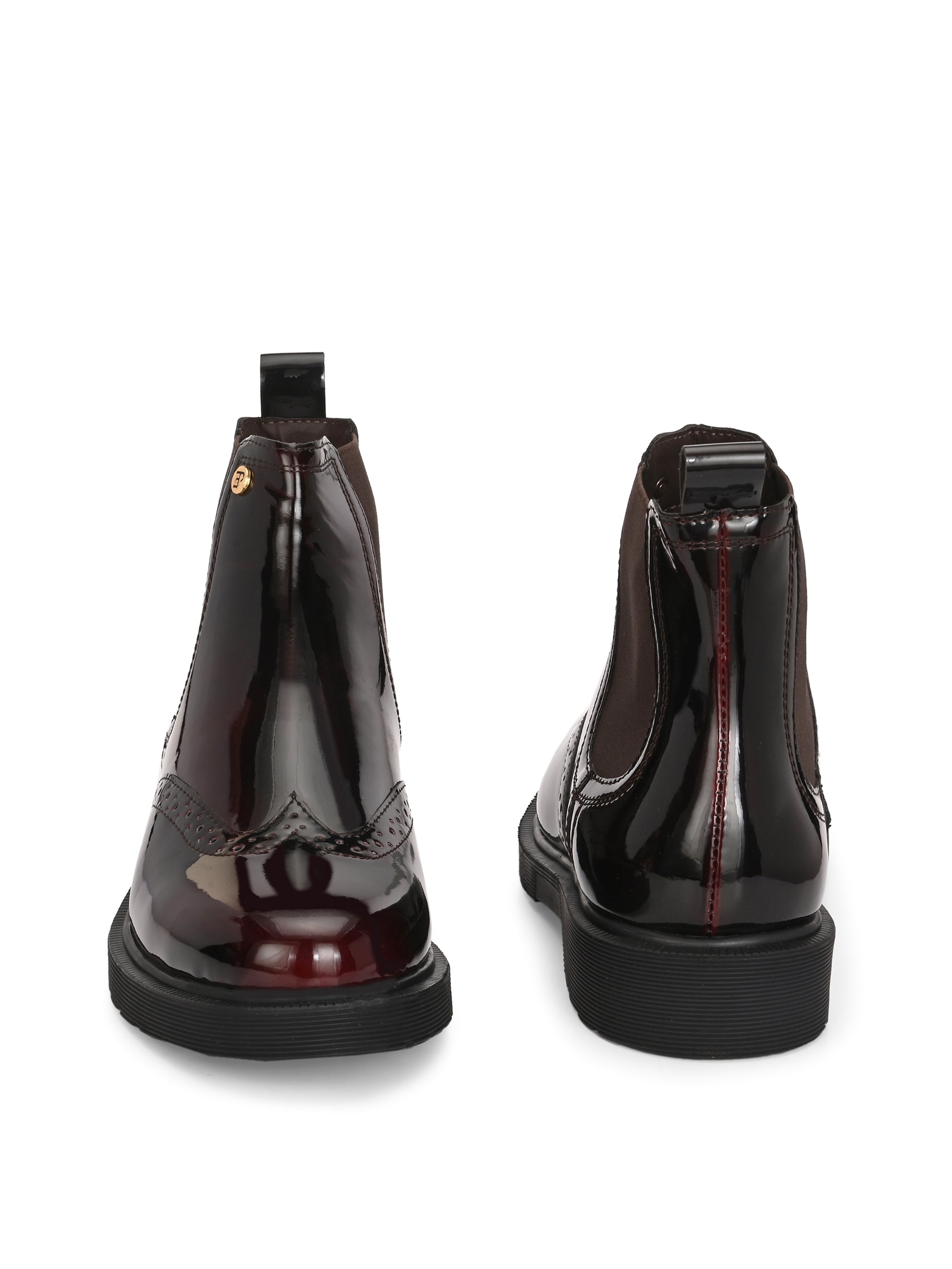 A glossy Wine Chelsea boot with brogue detailing, elastic side panels, and a durable black sole, featuring a gold accent logo.