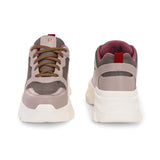 A chunky sneaker with a brown mesh upper, pink leather panels, brown laces, and a thick white sole.