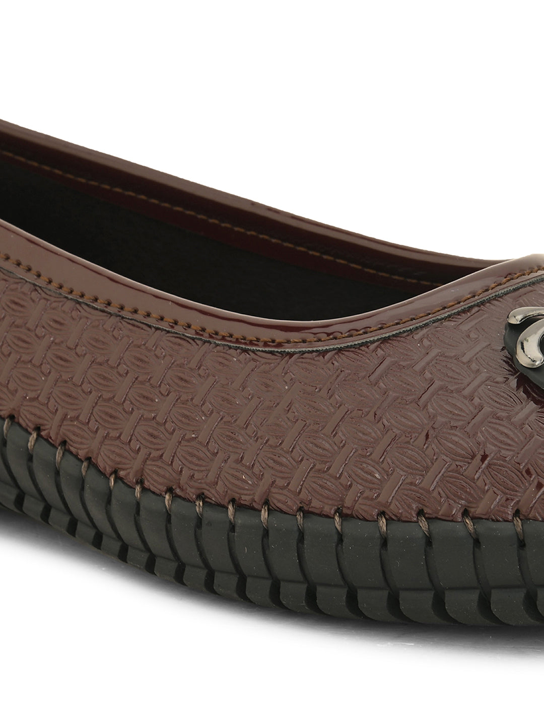 A brown woven-texture flat shoe with a round metal ornament on the toe and a black rubber sole.