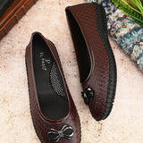 A brown Ballerina Flat with Bow for women, featuring a textured basket-weave upper, round toe, metallic bow detail, and a flexible black rubber outsole for comfort and casual wear.