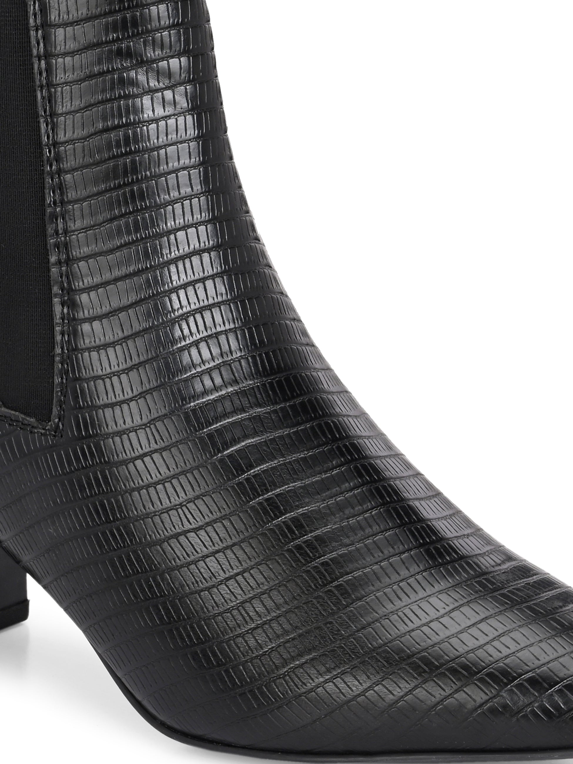 A stylish black ankle boot with a smooth leather finish, almond-shaped toe, mid-block heel, elastic side panel, and a gold accent logo.