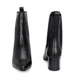 A stylish black ankle boot with a smooth leather finish, almond-shaped toe, mid-block heel, elastic side panel, and a gold accent logo.