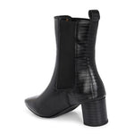 A stylish black ankle boot with a smooth leather finish, almond-shaped toe, mid-block heel, elastic side panel, and a gold accent logo.