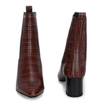 A stylish Tan ankle boot with a smooth leather finish, almond-shaped toe, mid-block heel, elastic side panel, and a gold accent logo.