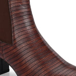 A stylish Tan ankle boot with a smooth leather finish, almond-shaped toe, mid-block heel, elastic side panel, and a gold accent logo.