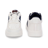 White lace-up sneakers featuring a navy blue stripe detail on the sides, perforated detailing on the toe, and a lightweight rubber sole.
