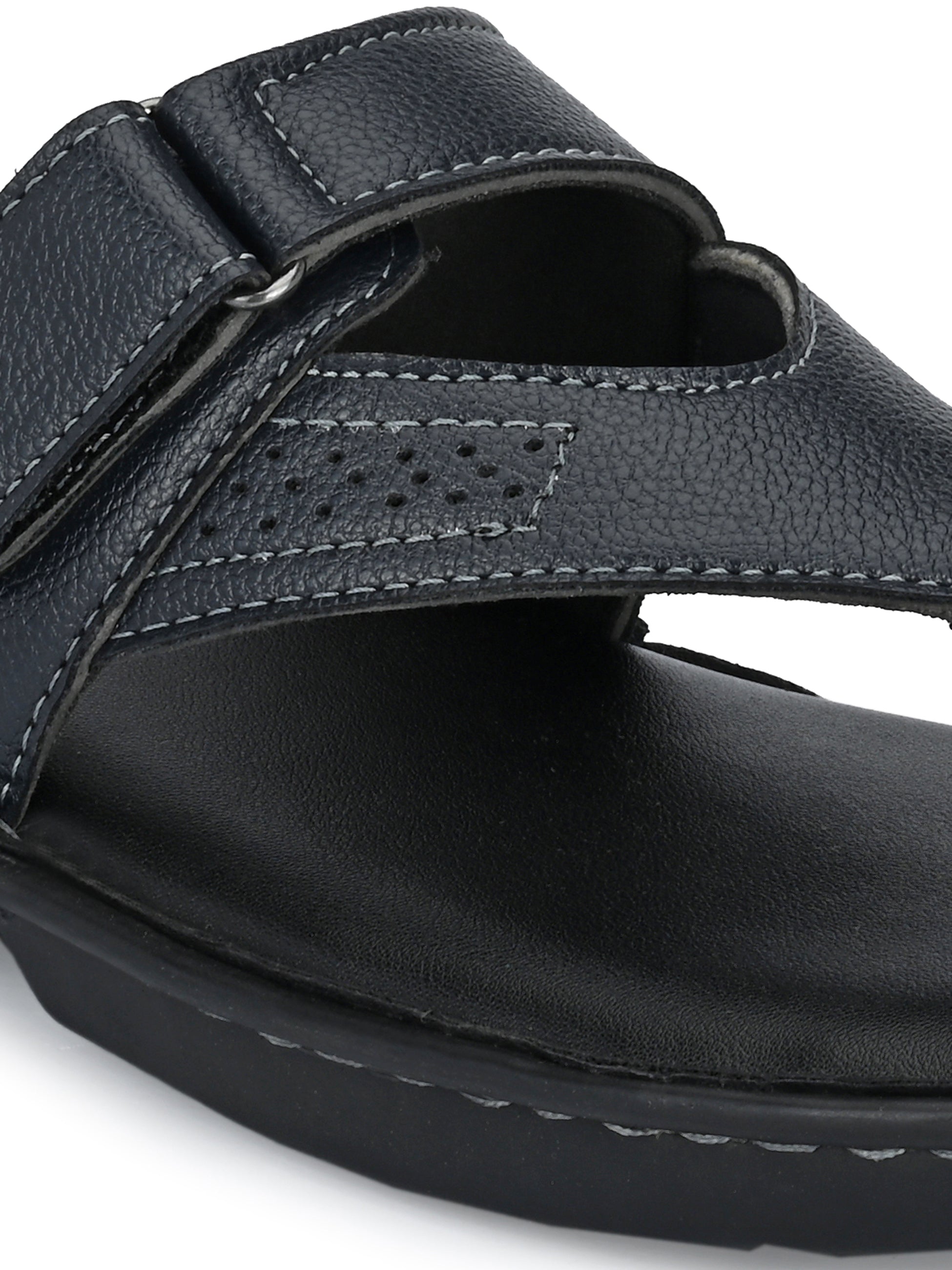 A navy blue leather sandal with a thong style and a padded footbed, featuring a curved strap design on a black sole.