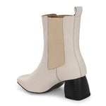 beige ankle boot with a smooth leather finish, elastic side panels, pull-tab, block heel, and pointed toe.