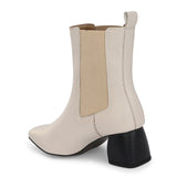 beige ankle boot with a smooth leather finish, elastic side panels, pull-tab, block heel, and pointed toe.