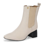 beige ankle boot with a smooth leather finish, elastic side panels, pull-tab, block heel, and pointed toe.