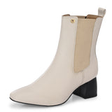 beige ankle boot with a smooth leather finish, elastic side panels, pull-tab, block heel, and pointed toe.