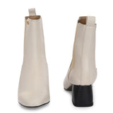 beige ankle boot with a smooth leather finish, elastic side panels, pull-tab, block heel, and pointed toe.